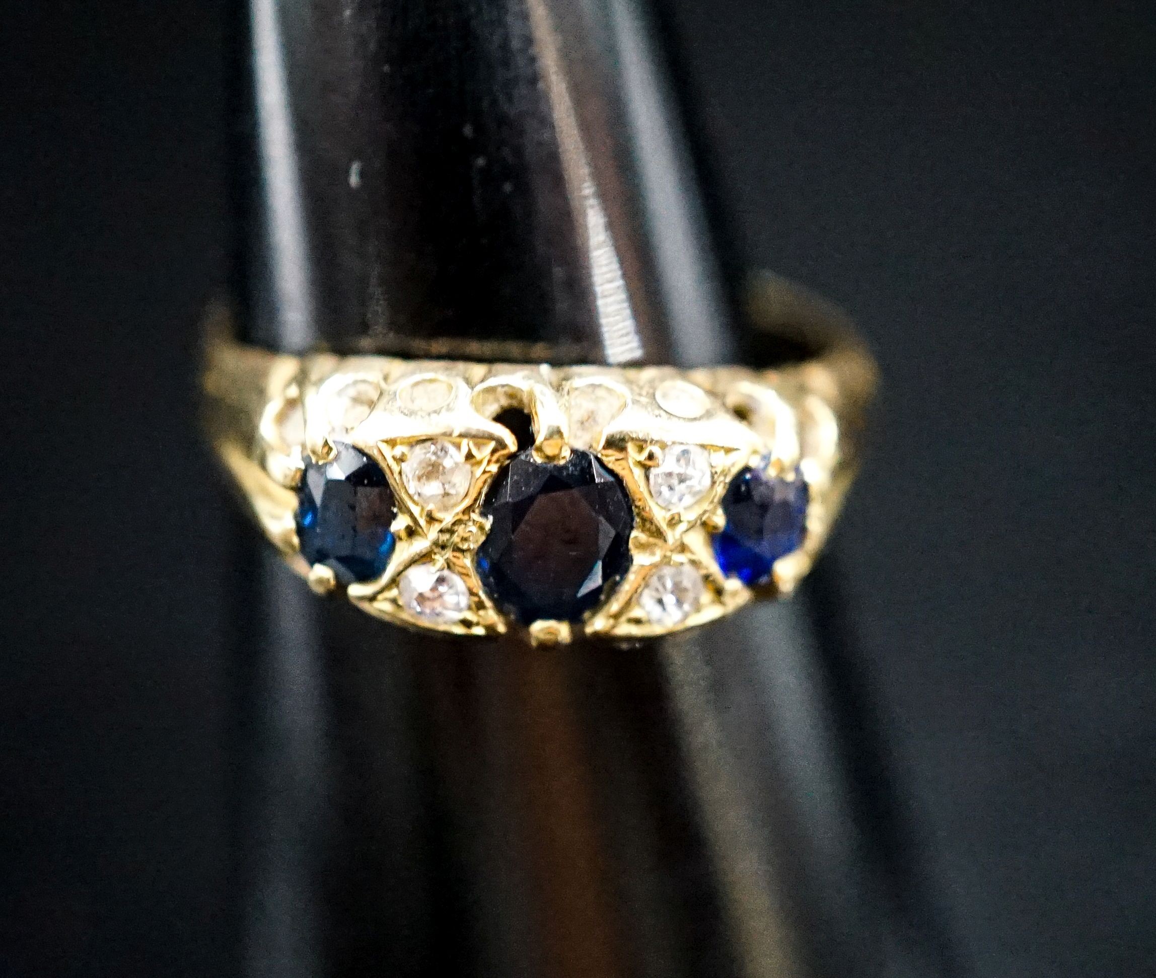 A late Victorian 18ct gold, three stone sapphire and four stone diamond chip set ring, size L, gross weight three grams.